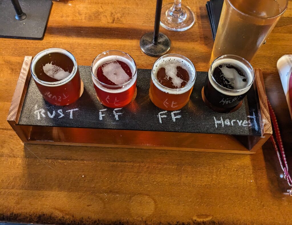 A flight of 4 different beers on a table.