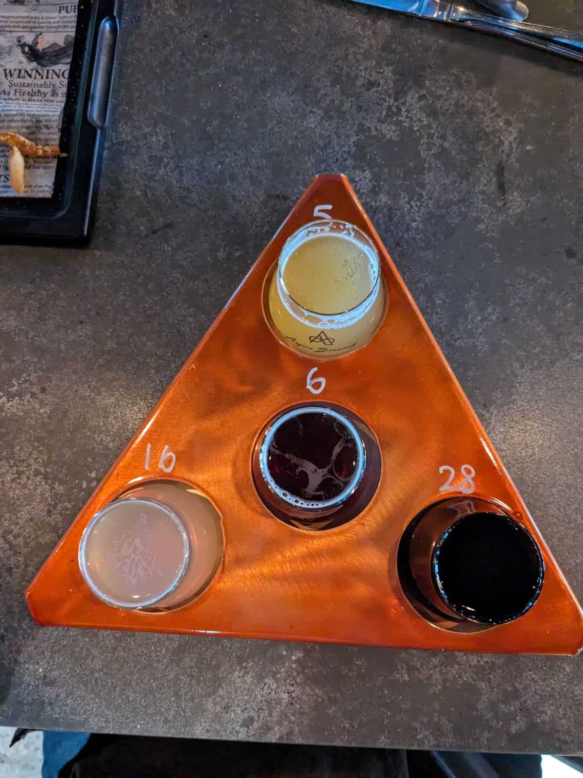 Flight of 4 beers on the bar.