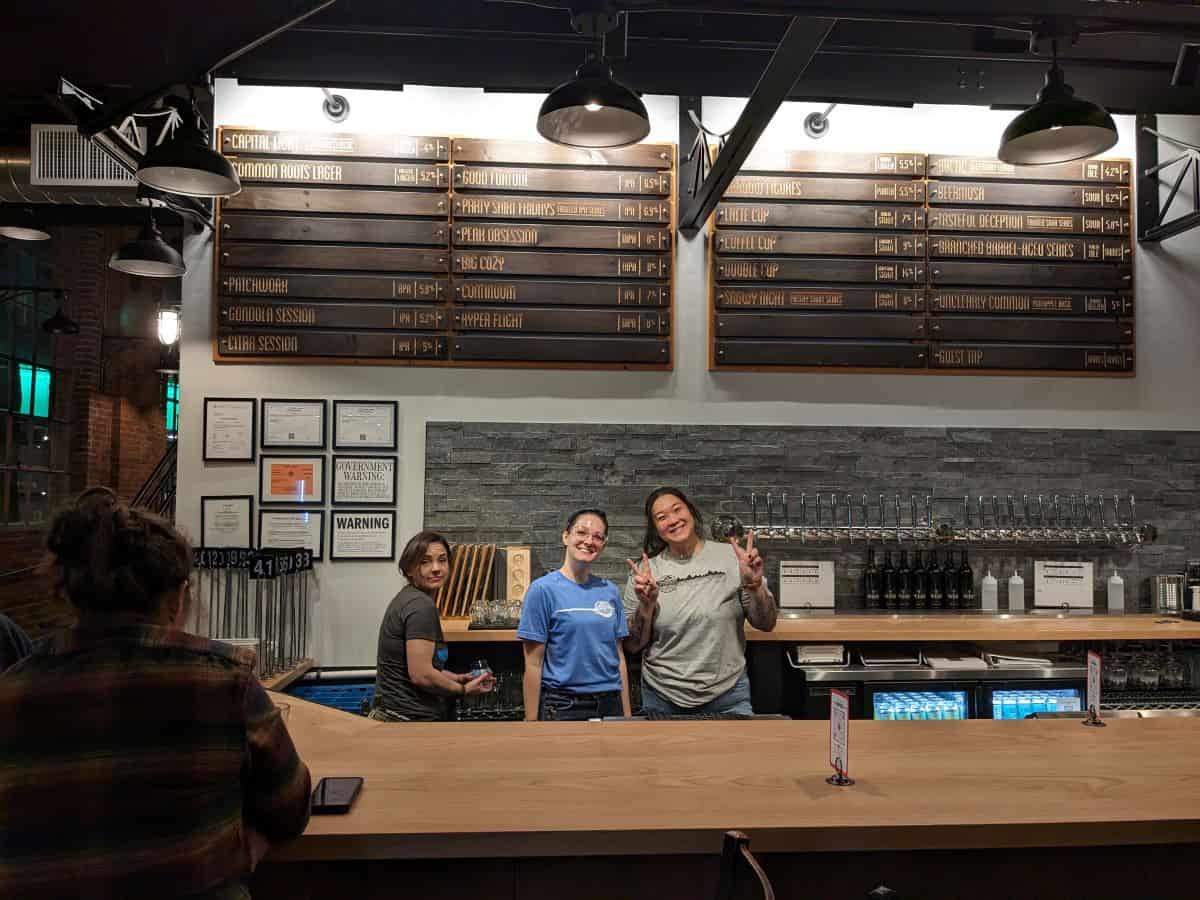 The bar with bartenders and the tap list hanging above.