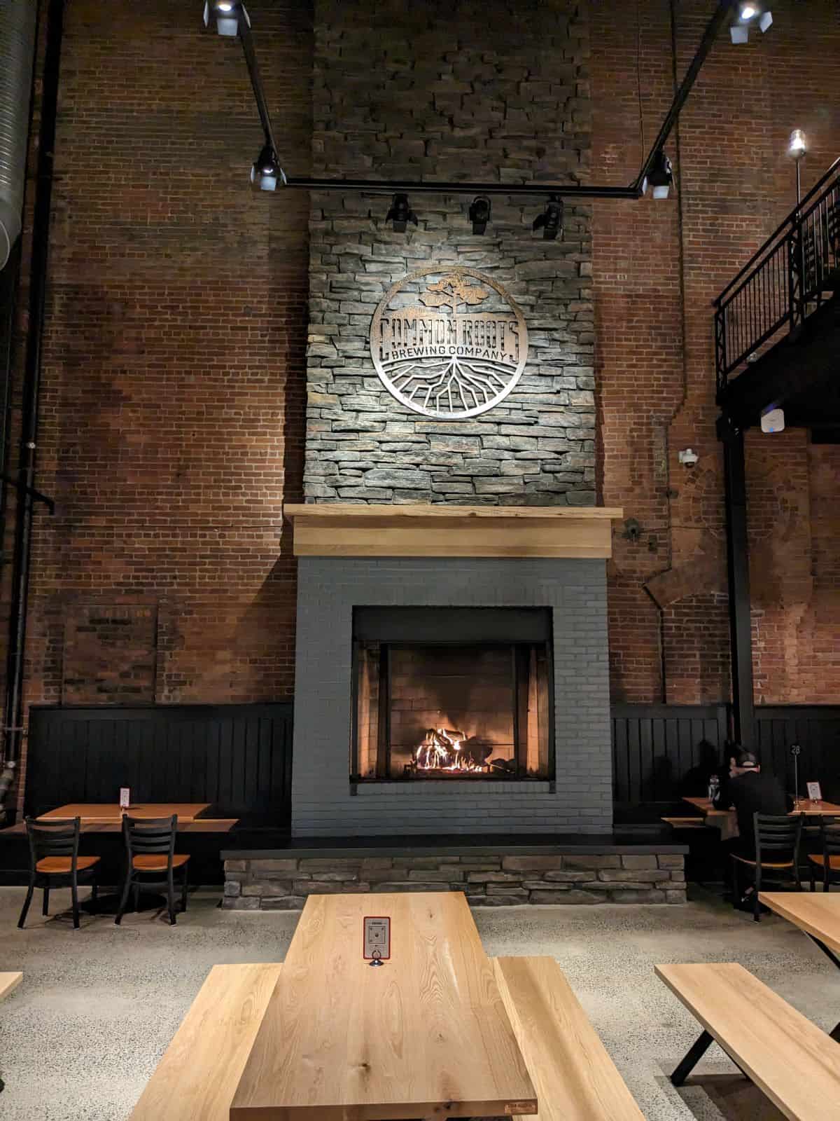 Common Roots Brewing Company logo over a fireplace.