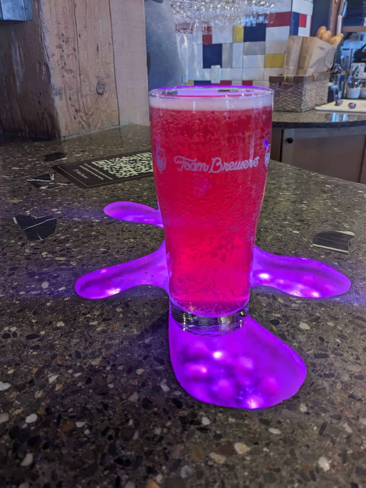 Glass of Blueberry kombucha on the bar.