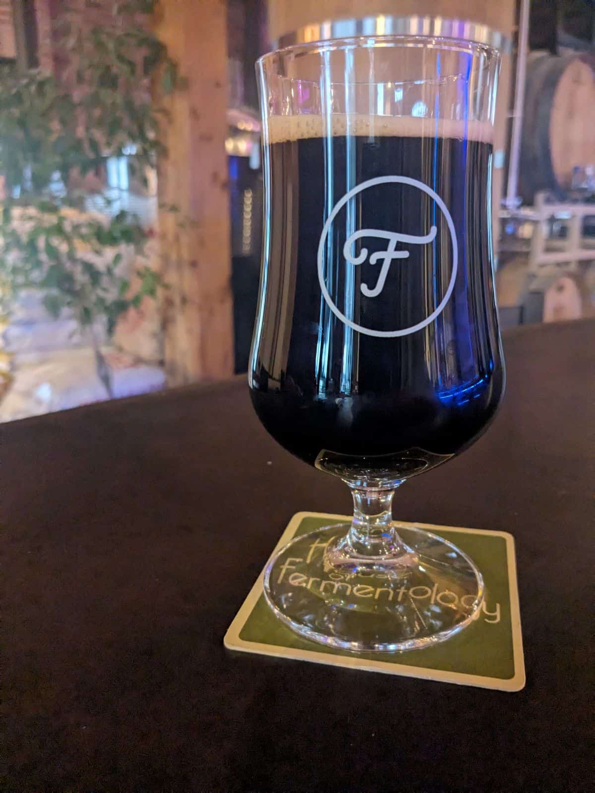 Glass of Heavy Water stout on the bar.