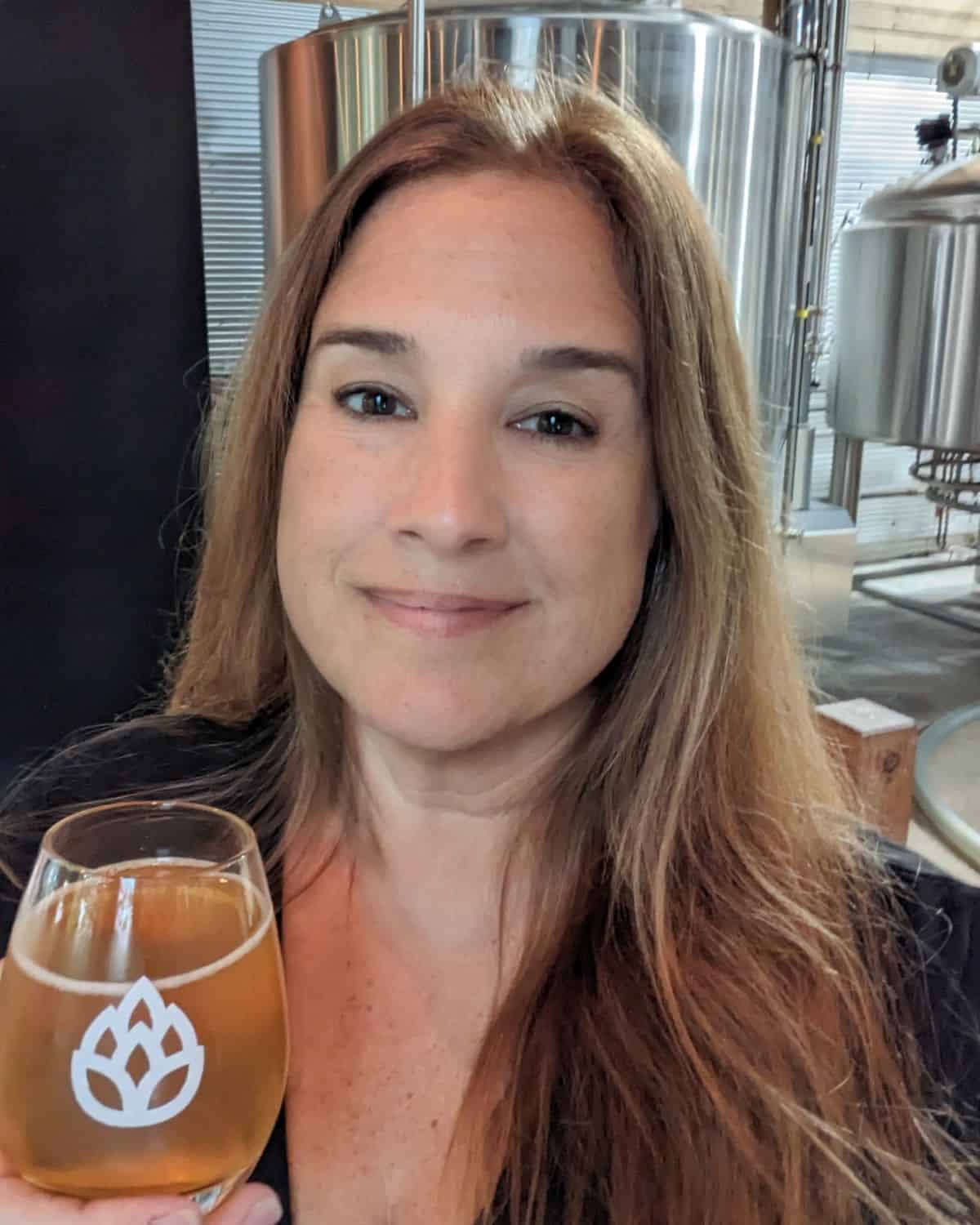 Jen smiling with a beer