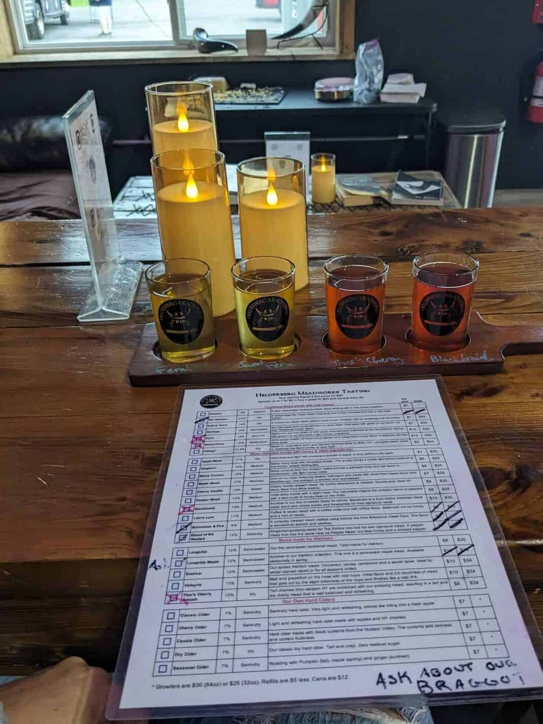 Mead flight of 4 on a table with candles.