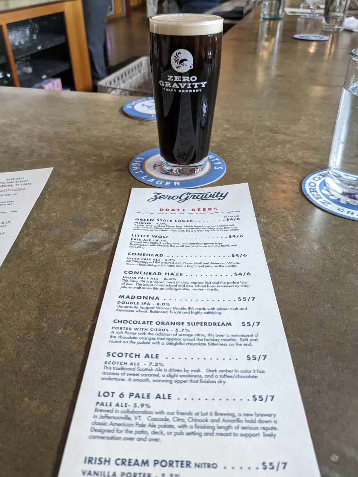 Glass of Porter and a beer list on the bar.