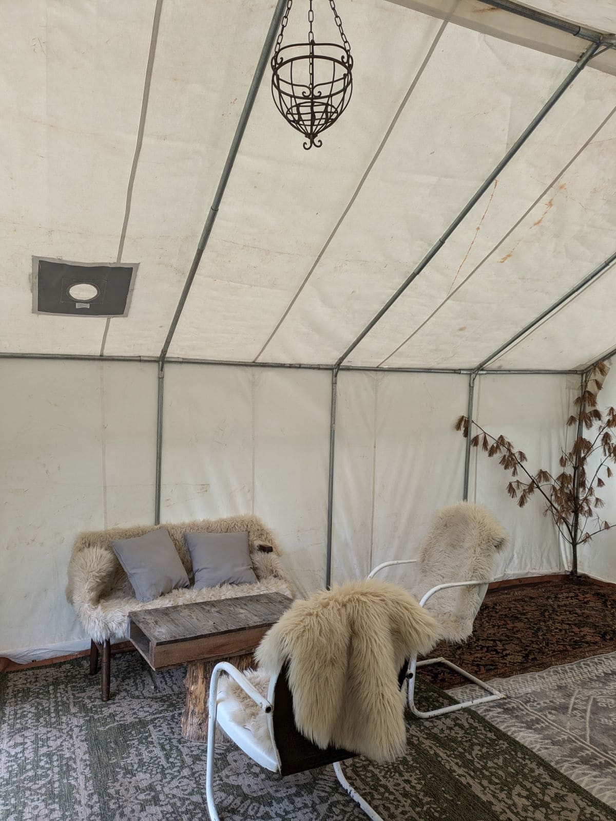 Tent with seating covered in fur throws.